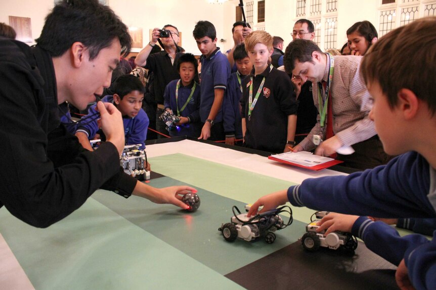 Students participating in RoboCup with robots playing soccer