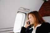 Businesswoman on the mobile in a private jet