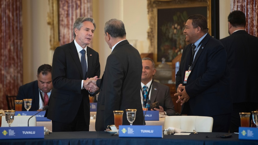 Men in suits shake hands.