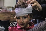 A little girl has head bandages applied