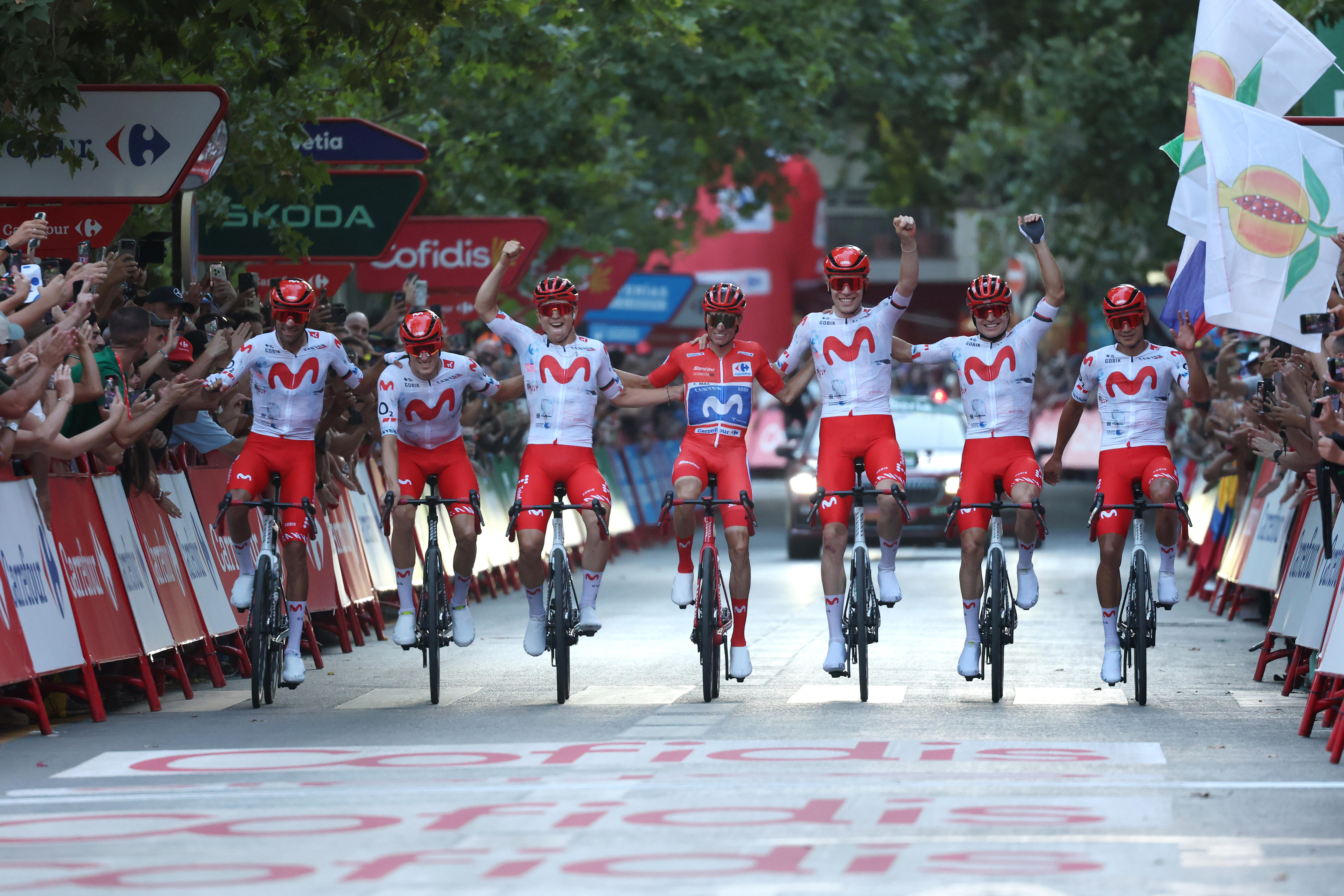 Movistar ride in a line linking arms