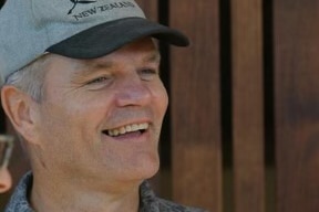 man in new zealand cap in profile, smiling looking off camera