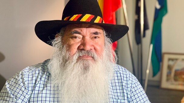 Image of an older Aboriginal man with a thick white beard, wearing a black hat.