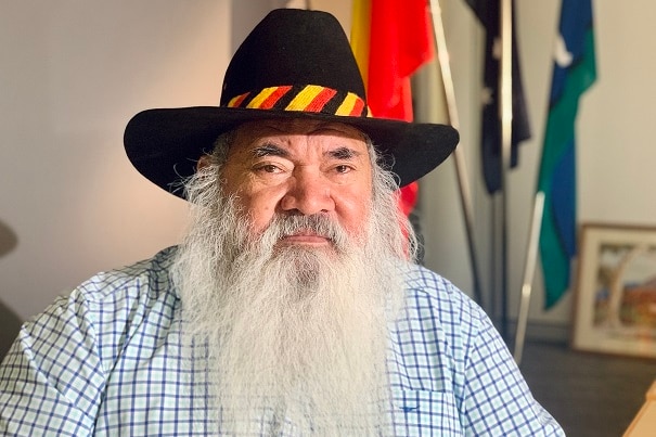 Image of an older Aboriginal man with a thick white beard, wearing a black hat.