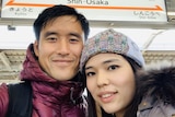 A selfie of a man and woman at a Japanese train station. 