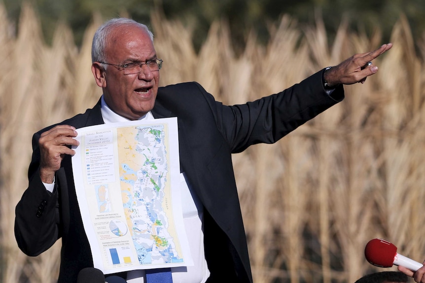 Palestinian Chief negotiator Saeb Erekat holds a map as he speaks about the Israeli plan to appropriate land.