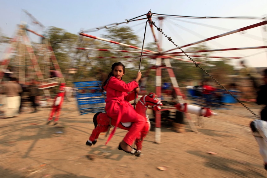 Girl rides on makeshift merry-go-round in Islamabad