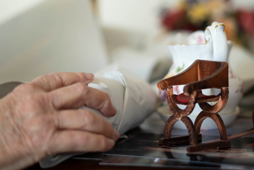 The hands of an older person with ornamental items