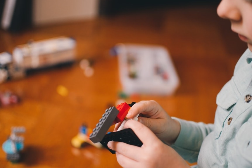 Toddler playing with plastic Lego blocls