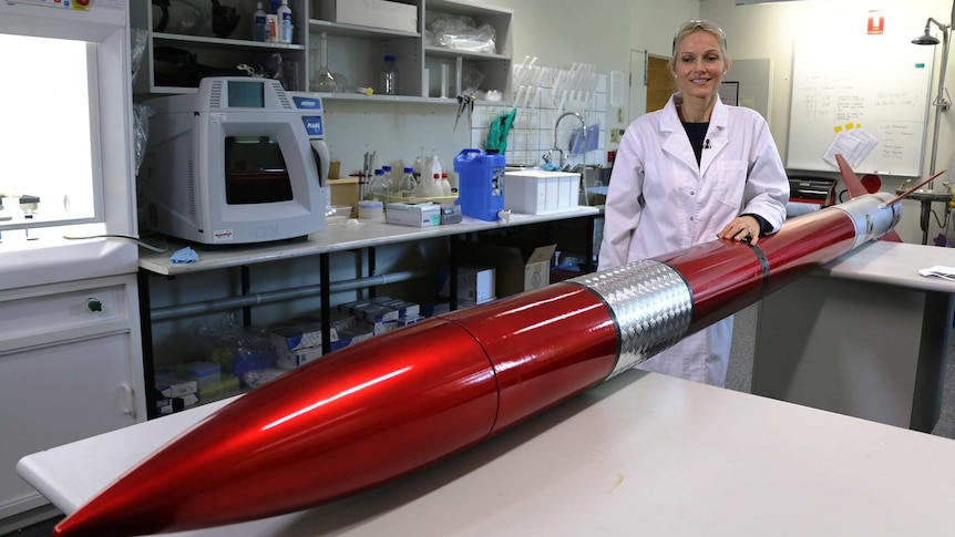 Samantha Ridgway in a laboratory with a large red rocket