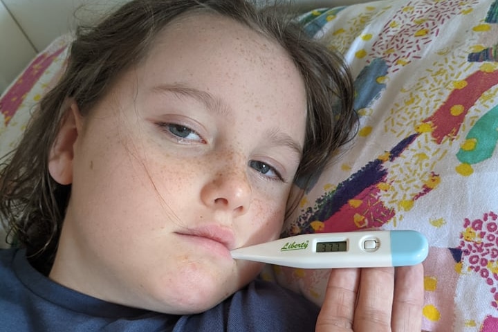 COVID-19 sick 11-year-old daughter of Kath Angus, with a thermometer reading of over 37C