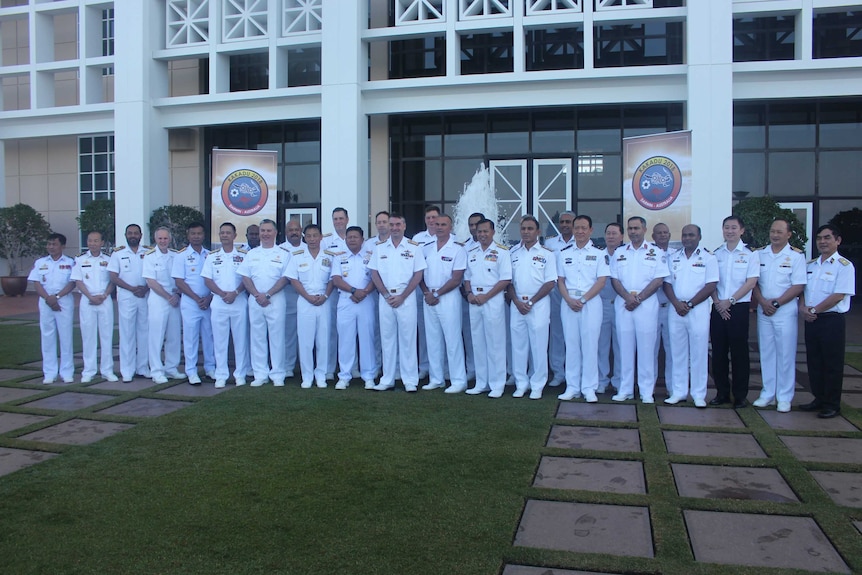 A senior navy representative from each of the 27 countries stands in front of NT Parliament House