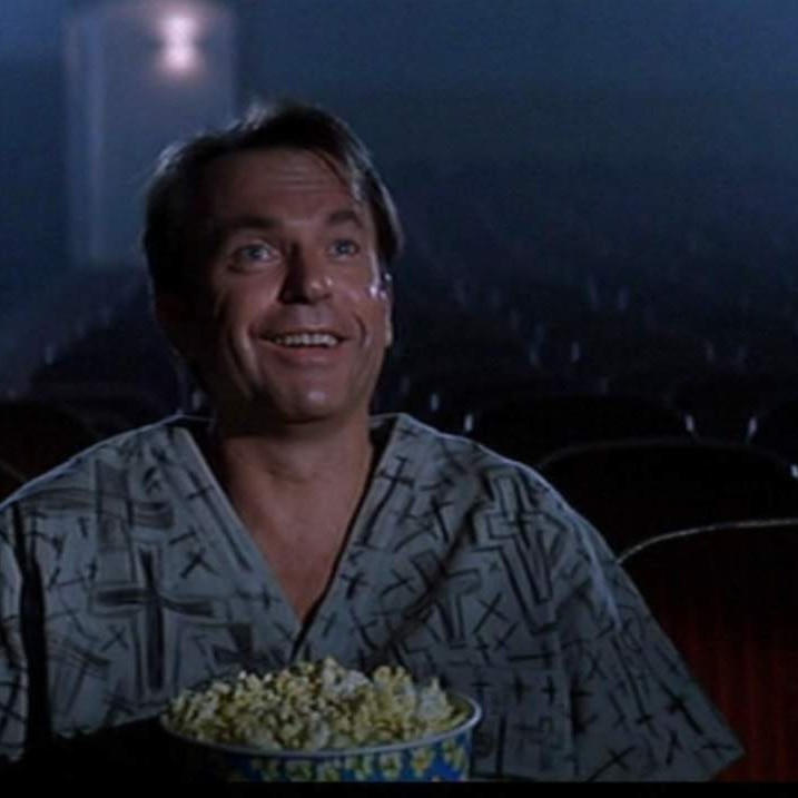 Sam Neil sitting in a cinema audience in the move In THe Mouth of Madness