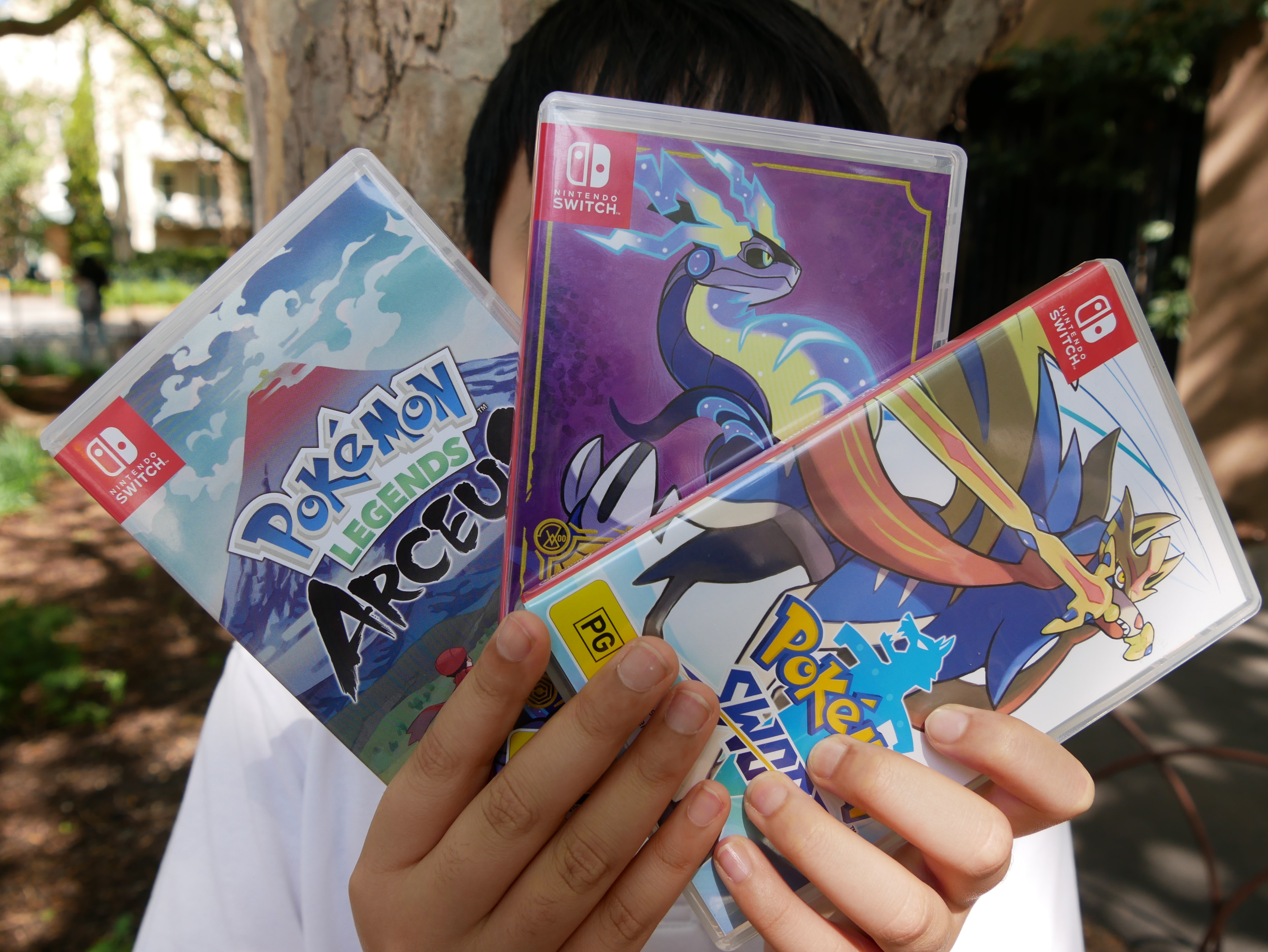 A boy holding up video game boxes