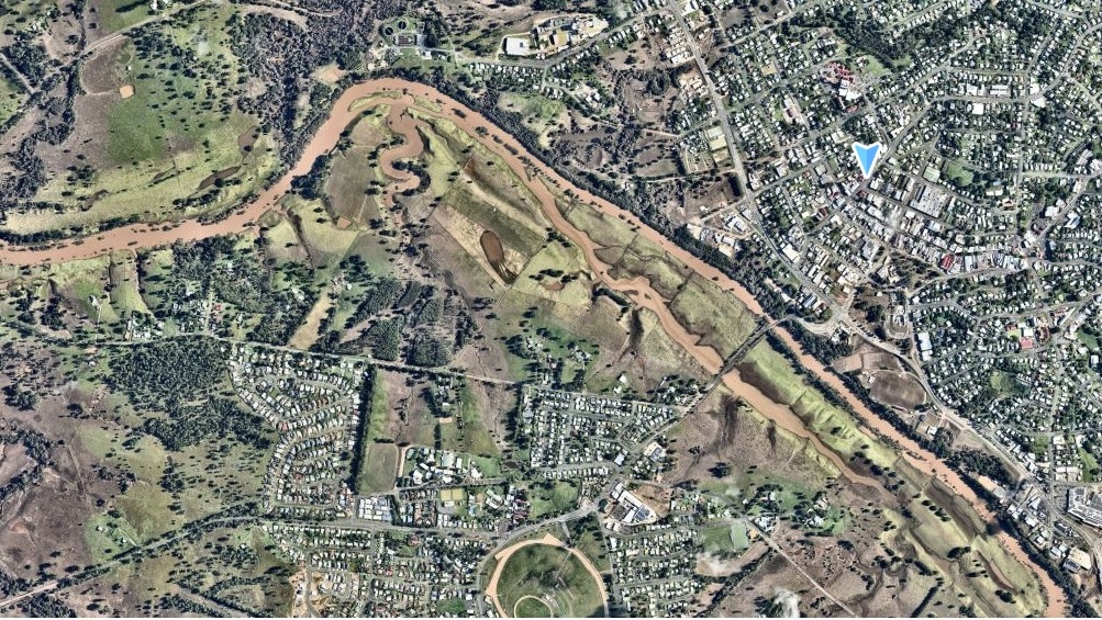 Brown flood waters stain the green countryside that surrounds the Gympie township. 
