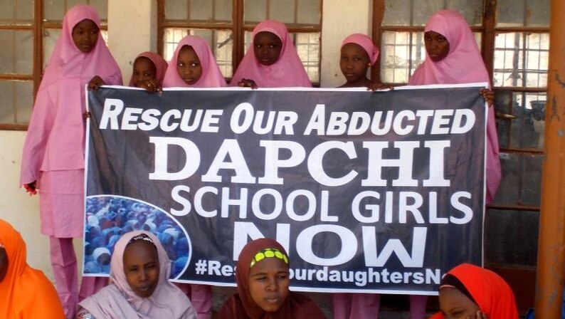 Nigerian school students hold a banner calling on President Buhari to rescue Dapchi students abducted in February 2018