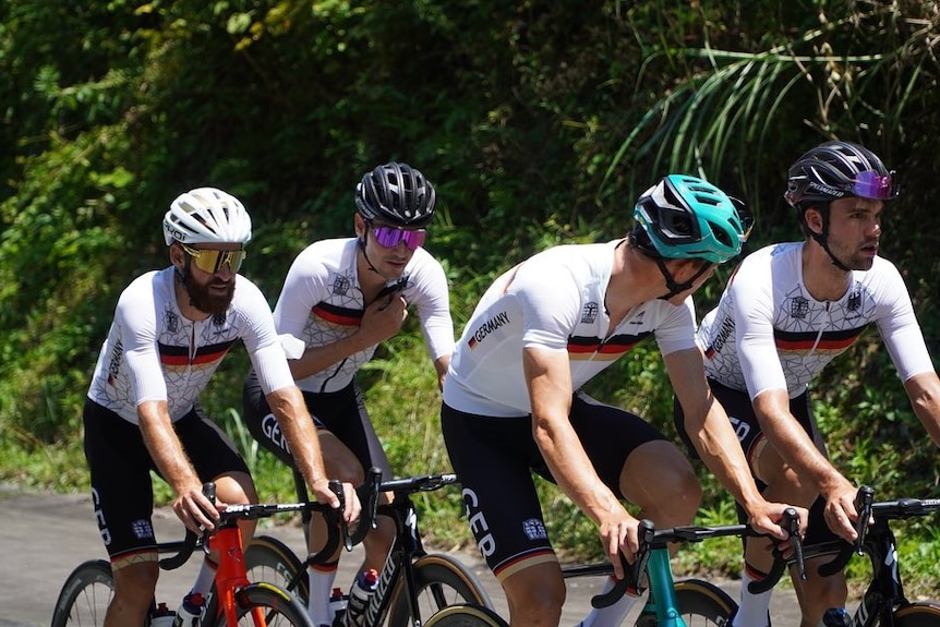 Four men cycling up a road 