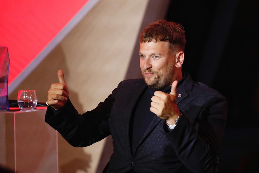 Dylan Alcott gives the thumbs up at an award ceremony where he was named 2022 Australian of the Year.
