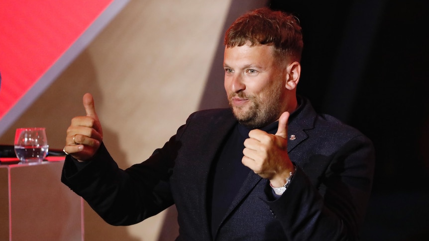 Dylan Alcott gives the thumbs up at an award ceremony where he was named 2022 Australian of the Year.