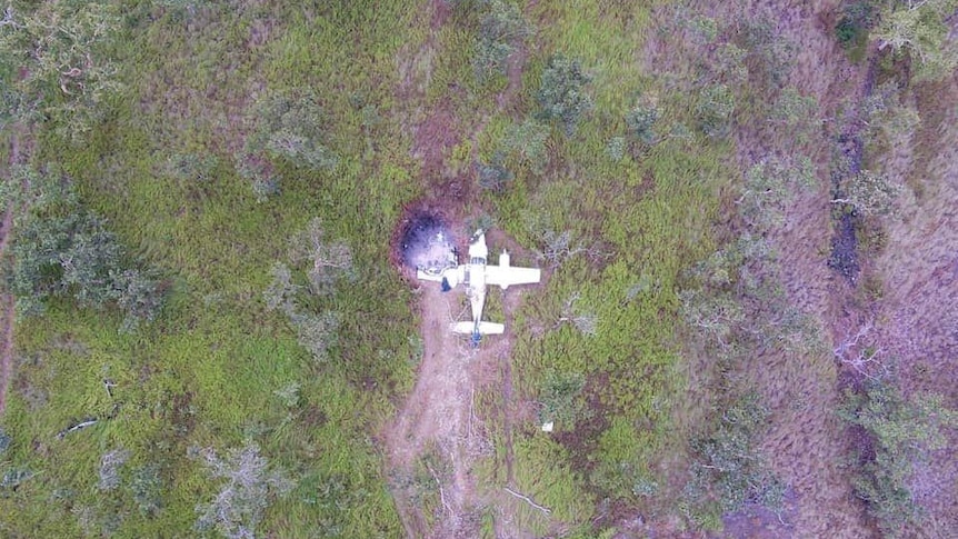 An aerial shot showing a crashed plane at the end of the makeshift runway in PNG.