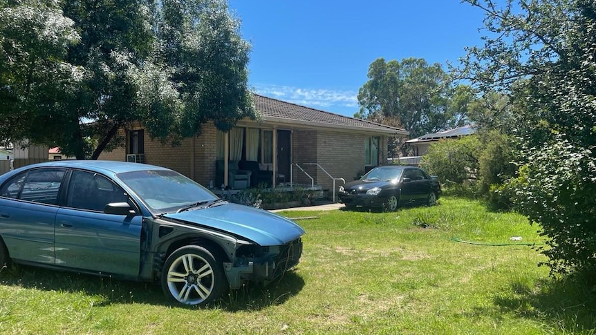 house with two cars parked on front lawn