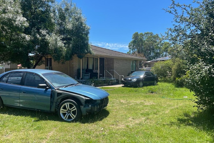 house with two cars parked on front lawn