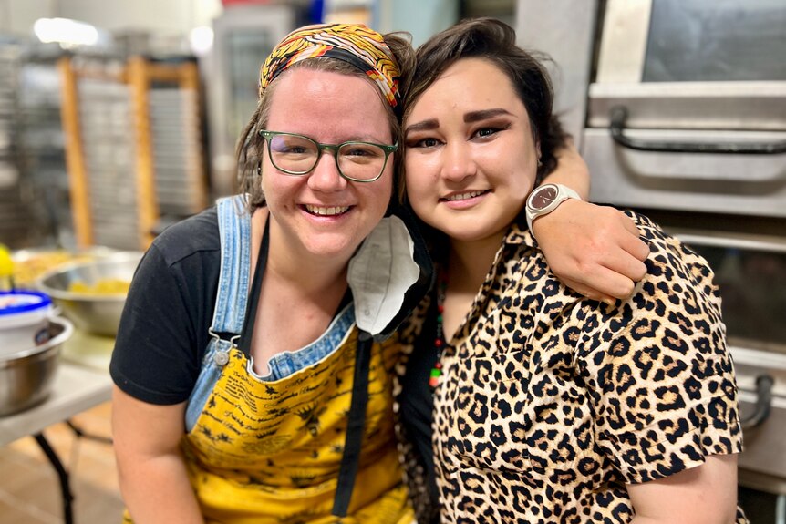 Two women hug in a kitchen
