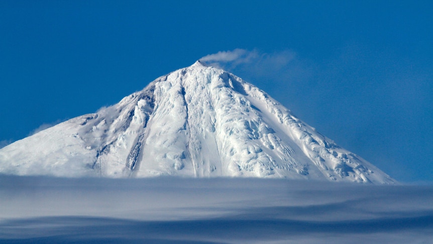 A snow-capped volcano erupts