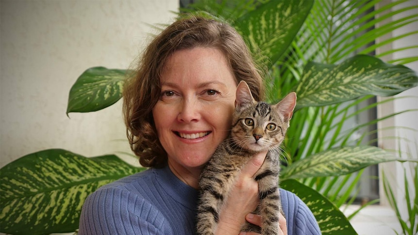 Mental health clinician and author Dianne Salvador holds a young tabby cat