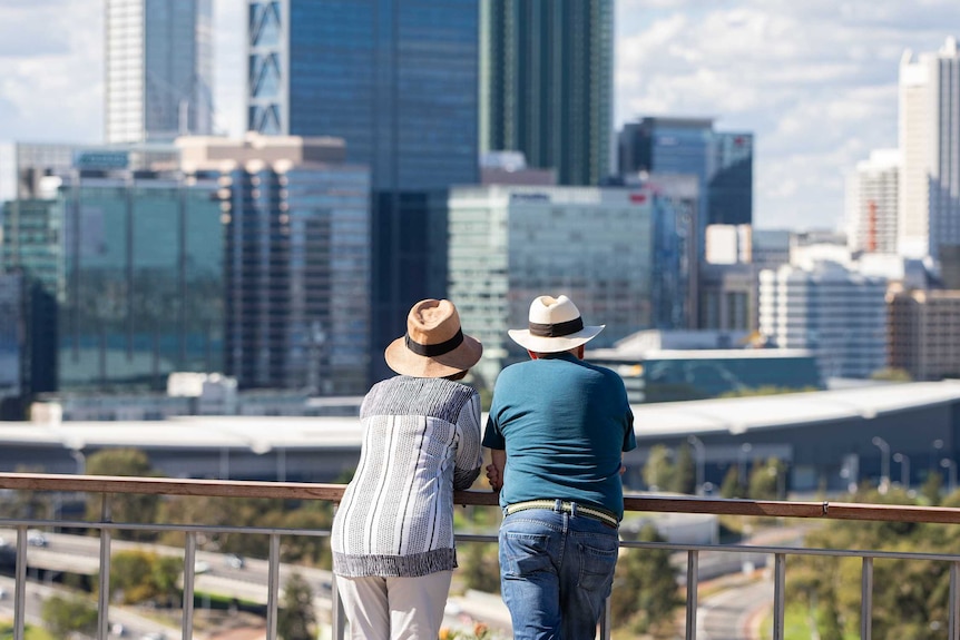 A couple look at the Perth skyline from a lookout spot at Kings Park.