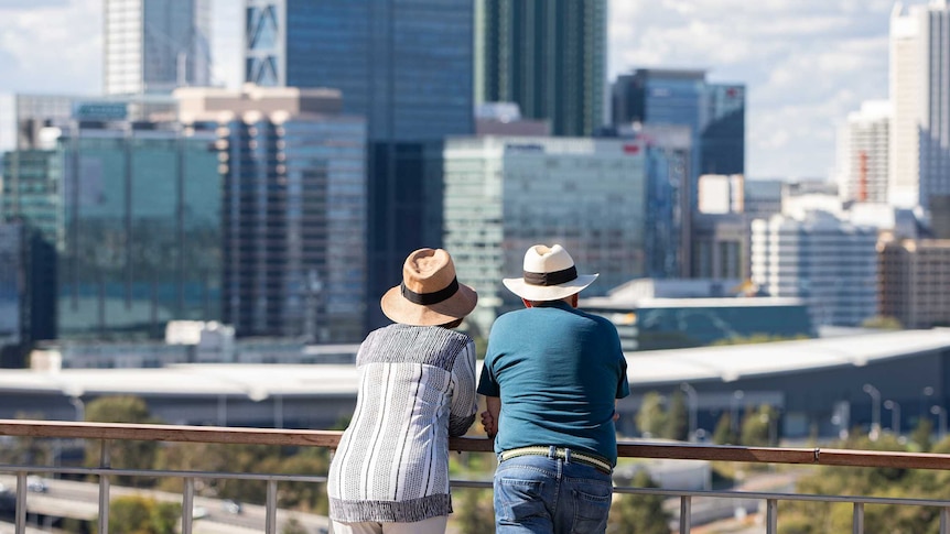 A couple look at the Perth skyline from a lookout spot at Kings Park.