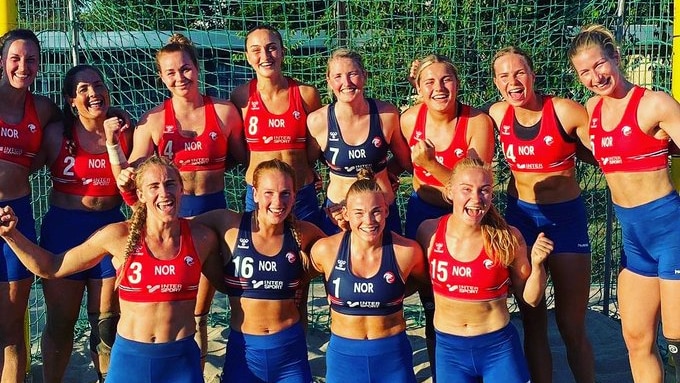 Smiling women wearing athletic wear on a beach court.