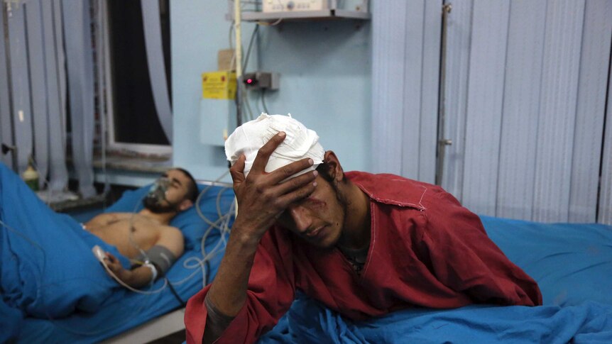 Injured men receive treatment at a hospital after a suicide bombing in Kabul, Afghanistan.