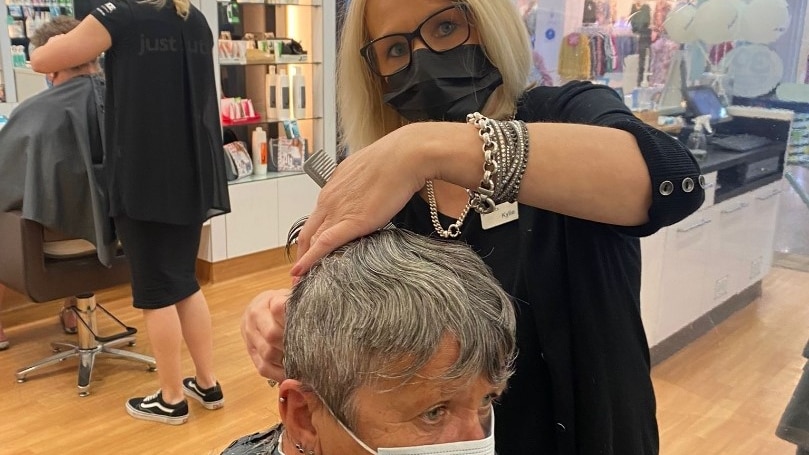 a woman cuts hair in a salon