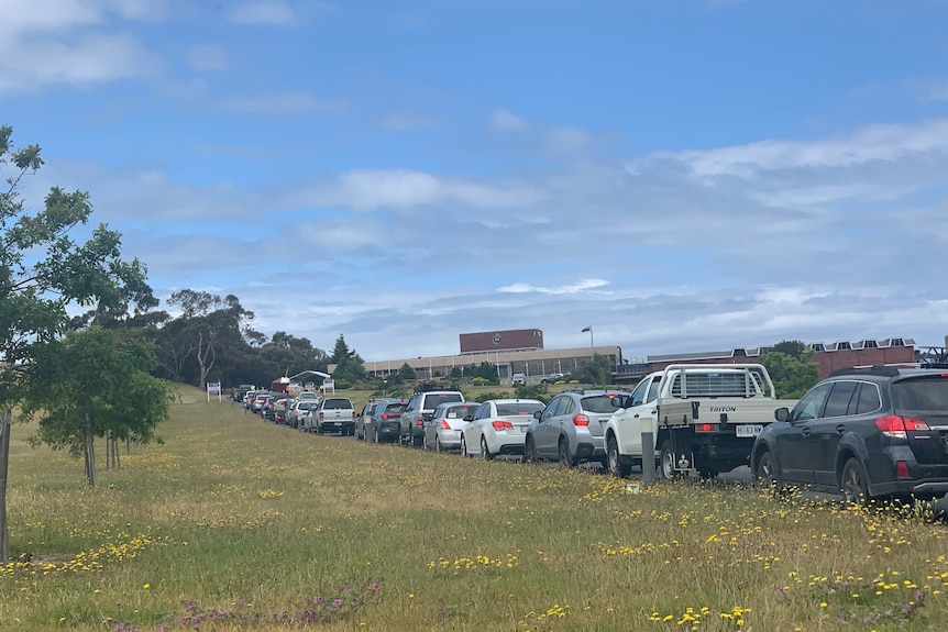 Cars queue along the side of a road.