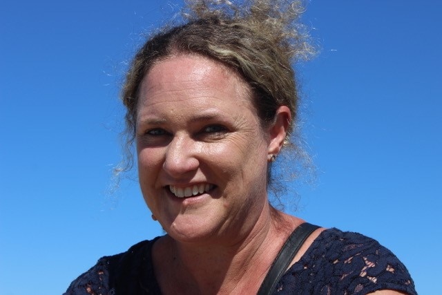 A smiling Dr Linda Davies with a blue sky background.