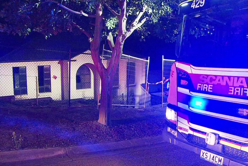 A two storey house with a firetruck in the foreground 