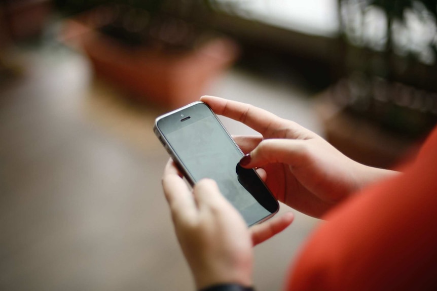 Two hands holding a mobile phone.