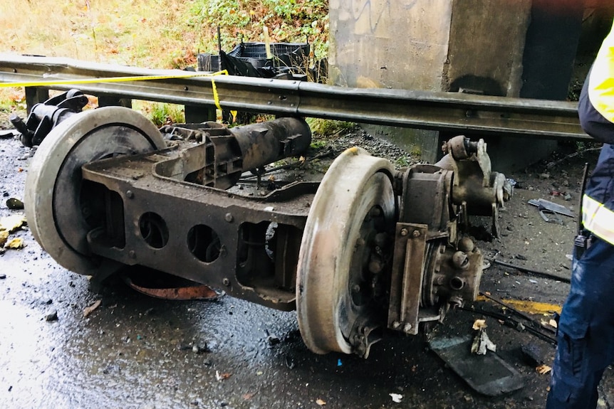 Train wheels broken from a train are seen on a road.