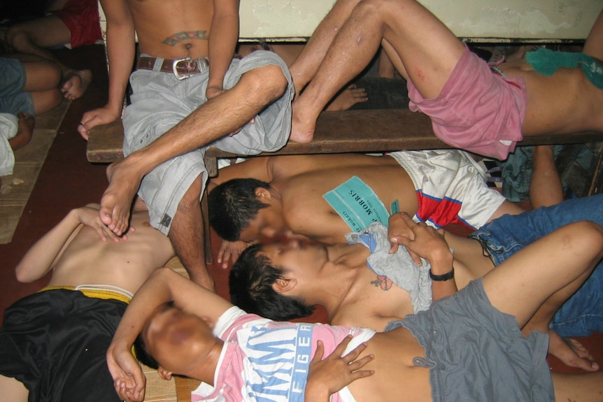 Prisoners in the Philippines lie on a jail floor