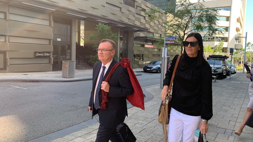 woman walking outside court house, wearing glasses