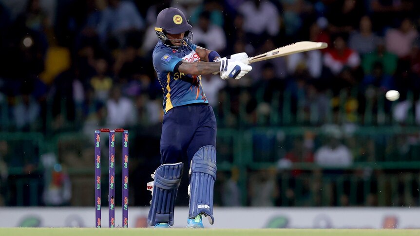 A Sri Lankan batsman follows through his pull shot as the ball at the edge of picture rockets to the boundary.
