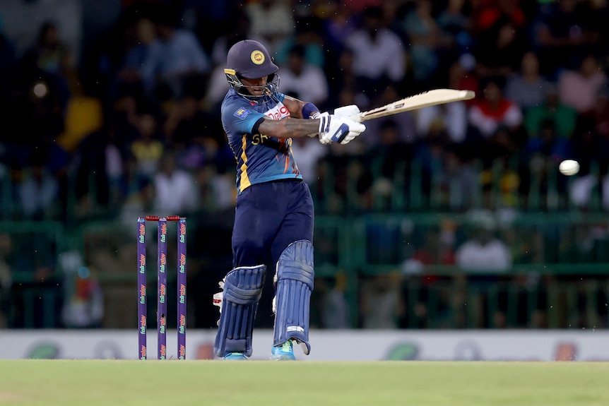 A Sri Lankan batsman follows through his pull shot as the ball at the edge of picture rockets to the boundary.