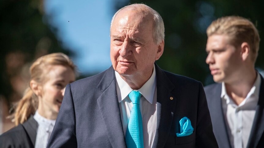 Alan Jones walks with lawyers outside the Supreme Court in Brisbane.