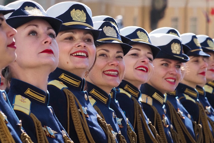 Female military personnel smile during a march in St Petersburg