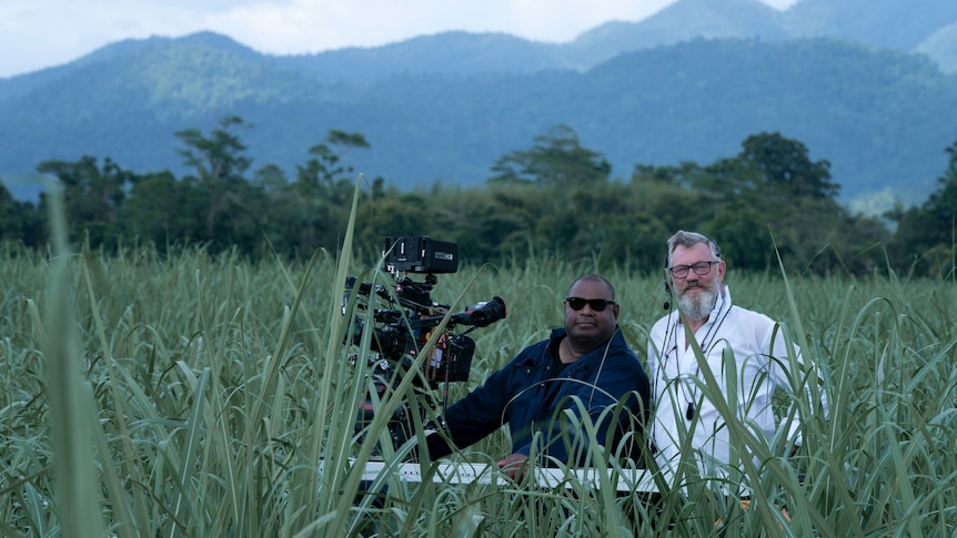 two men standing in cane field