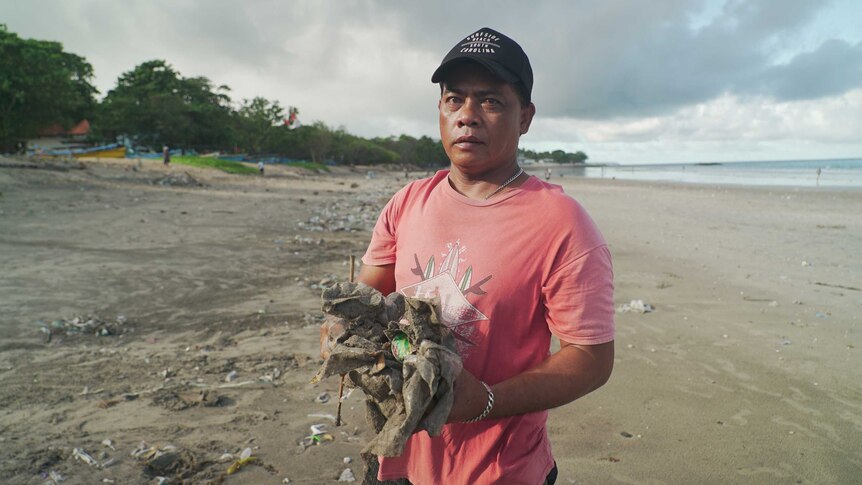 Edi Karyadi holds garbage on a Bali beach