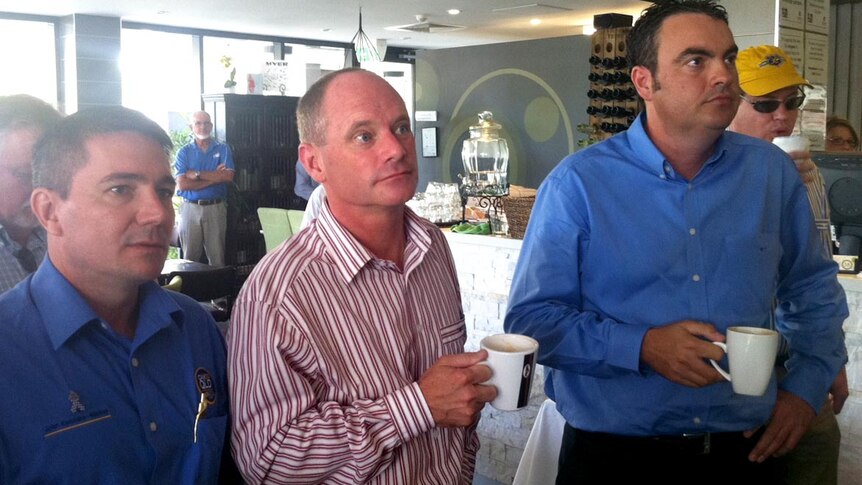 LNP Leader Campbell Newman, campaigning in Mackay, watches Prime Minister Julia Gillard speak on TV.