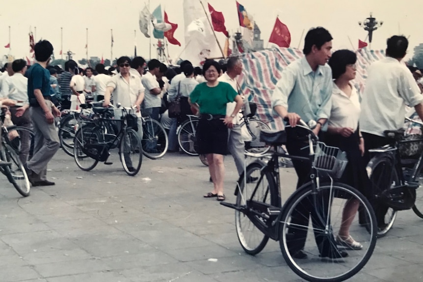 Liling Wang poses in a crowded street in 1989, surrounded by people pushing bikes. 