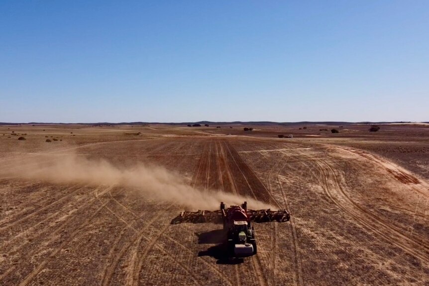 A drone shot of a tractor planting seeds